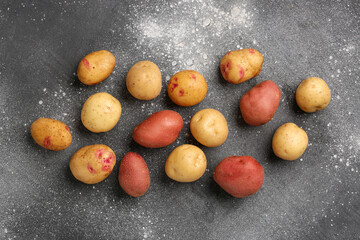 Fresh raw potatoes on grey background