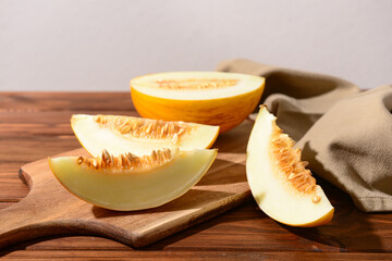 Board with pieces of sweet melon on wooden table