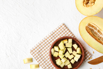 Bowl with pieces of sweet melon on white background