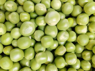 Close-up of fresh green peas in a pod, showcasing their vibrant color and natural texture