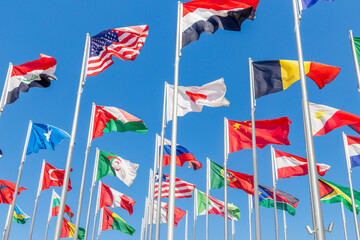 Many world's countries national flags waving together on the wind, with American, Japanese, Omani,...