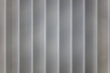 Fototapeta premium Modern Building Exterior with Vertical Metallic Lines and Glass Facade Pattern