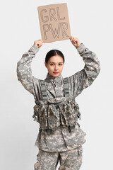 Young female soldier with sign GRL PWR on white background. Feminism concept