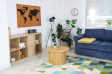 Blurred view of stylish living room with shelf unit and table