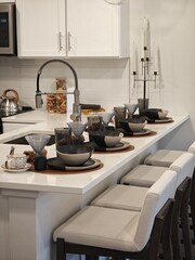 Elegant kitchen setting with modern decor and stylish tableware creates a welcoming atmosphere for gatherings