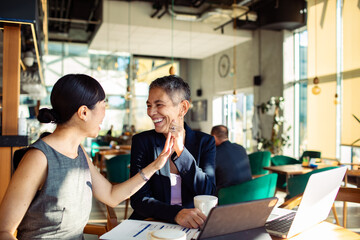 Diverse business people having meeting in modern cafe