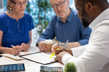 Insurance broker highlighting the important contract terms, discussing with senior couple about a...