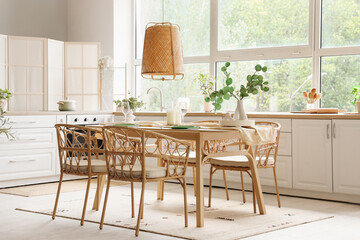 Served dining table with chairs and hanging lamp in interior of kitchen