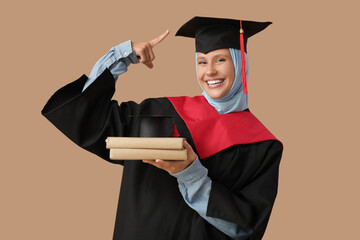 Muslim female graduating student with books on beige background