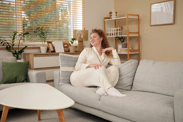 Beautiful young woman relaxing on sofa at home. Day off concept