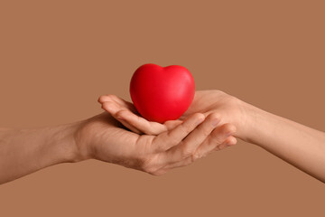 Couple holding heart on brown background
