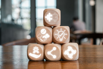 Wooden blocks with synergy icons symbolizing teamwork, innovation, and connectivity in a...