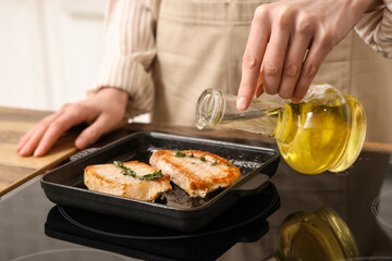Woman frying tasty steak in kitchen