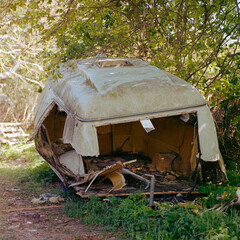 Broken caravan under tree