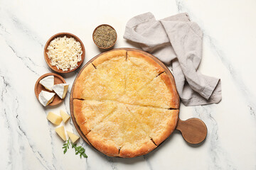 Tasty pizza with pieces of cheese and spices on marble background