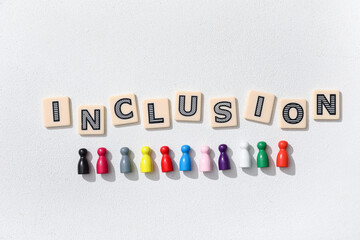 Word INCLUSION and colorful pawns on white background