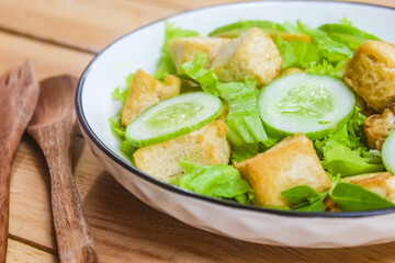 close-up of a plate of tofu salad on a wooden plate