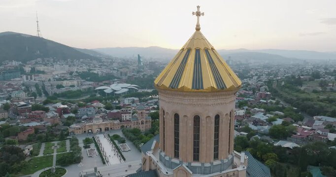 The drone rotates in a circular motion around the golden dome of the Holy Trinity Cathedral (Sameba Cathedral), one of the symbols of Tbilisi.