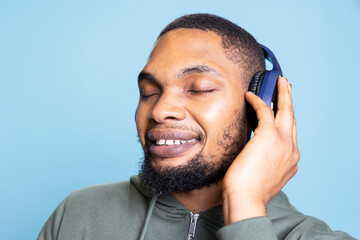 African american person acting joyful and euphoric in studio, singing and dancing on his music on...