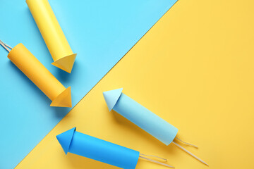 Blue and yellow firework rockets on color background