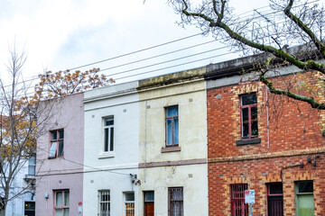 A row of historic terrace houses in Fitzroy, Melbourne, Australia with a mix of Victorian and Edwardian styles of architectural character. Old residential suburban homes in inner-city suburbs.