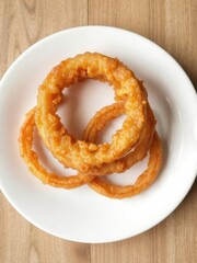 Crispy fried onion ring served on a clean white plate, unhealthy, white, onion ring