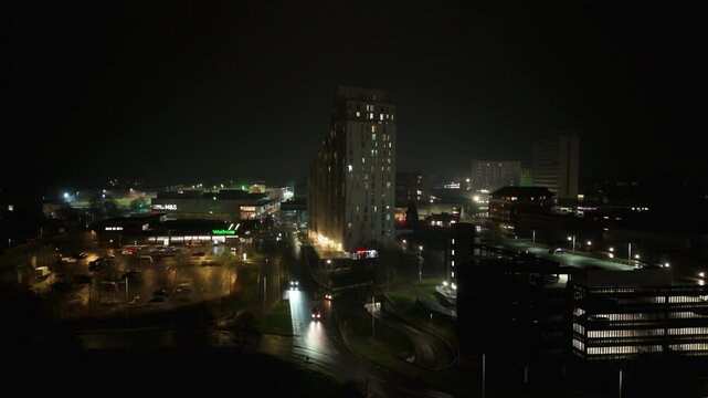 Night view of illuminated Bracknell town centre with cars driving on roads