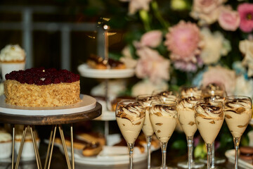 Candy bar. wedding cake decorated by flowers standing of table with desserts and cupcakes. Wedding. Reception Tartlets