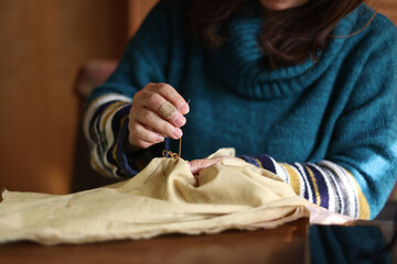 手縫いで刺繍する女性