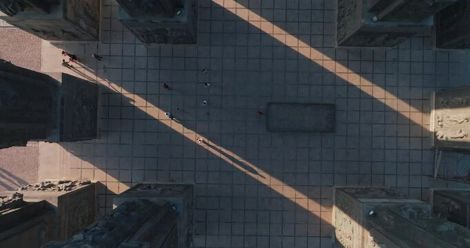 Aerial view of Georgian Historical Monument in Tbilisi. Lengthening shadows and people are seen. The drone soars upwards, revealing the size and symmetry of the structure.