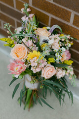Brightly colored flower bouquet arranged against a brick wall