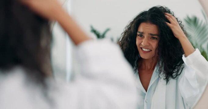 Hair, messy and mirror with woman in bathroom of home for daily or morning haircare routine. Frizz, knot and split ends with reflection of unhappy person in apartment for organic shampoo treatment