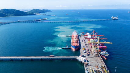 Tug boat pulling Cargo container ship go to international yard port. technology freight shipping...