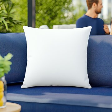 White square throw pillow on a blue outdoor couch.