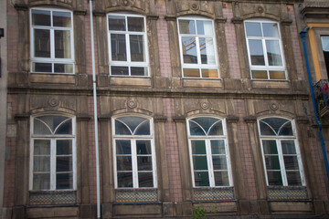 Aged building with large windows in Porto, Portugal.
