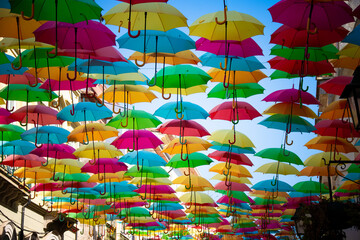Street in &Aacute;gueda with colorful umbrellas and benches.