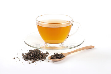 Glass cup of hot tea with dry tea and spoon on white background.