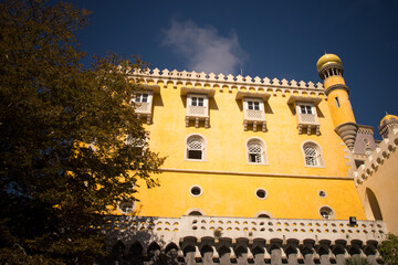 Obraz premium Pena Palace towers with red and yellow facade under blue sky.