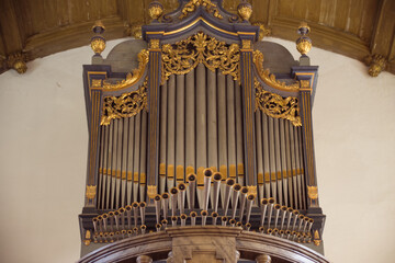Close-up of a beautifully ornate church organ in a historic interior.