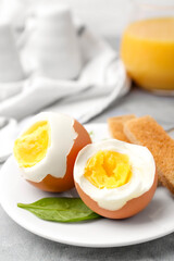 Soft boiled eggs with bread on grey table, closeup