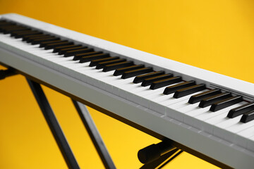 Synthesizer on yellow background, closeup. Electronic musical instrument