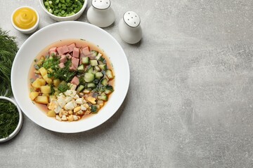 Delicious okroshka soup and ingredients on grey table, flat lay. Space for text
