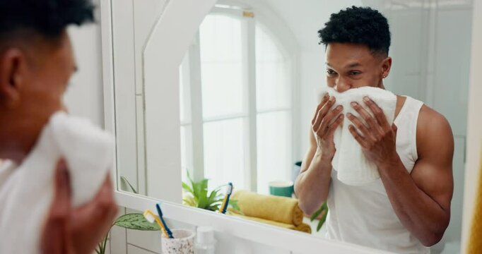 Man, mirror and towel for skincare in bathroom with results or face reflection for grooming in morning. Pat dry, facial glow or male person in home with cloth fabric, hygiene and beauty at apartment