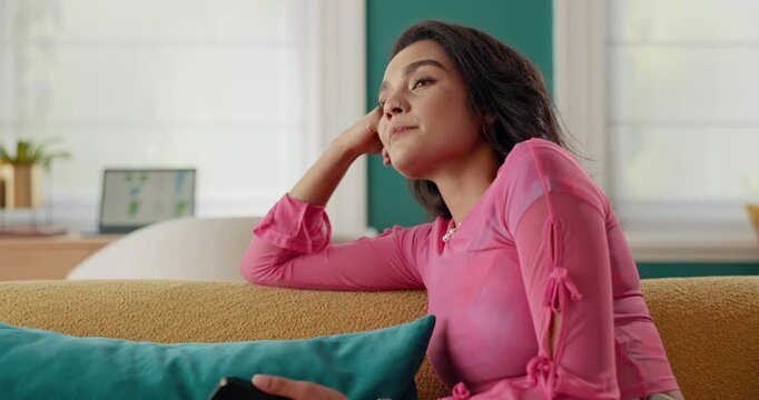 Calm woman, relax and waiting with phone on sofa for online order, delivery or anticipation at home. Female person, shopper or customer thinking with mobile smartphone for ecommerce, ETA or courier