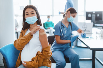 flu Vaccination Concept. Portrait Of Asian Lady In Surgical Mask Showing Vaccinated Arm With...