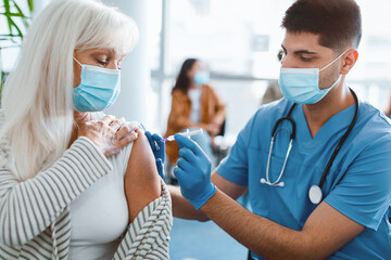 Immunization, Prevention Procedure Concept. Closeup Of Elderly Woman In Surgical Mask Receiving...