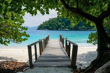 Naklejka premium Tropical beach boardwalk leads to turquoise sea, lush foliage canopy