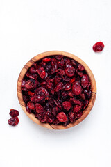 Organic sun dried cranberries in bowl on white background, top view