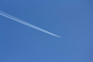 青空の中を飛ぶ飛行機と飛行機雲 Plane and contrail flying in the blue sky