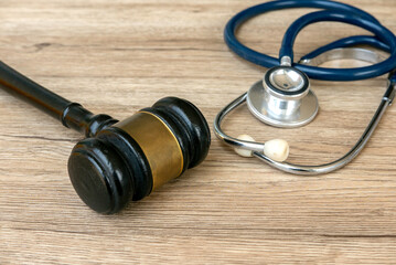 Gavel and Stethoscope on Wooden Surface Representing Legal and Medical Professions